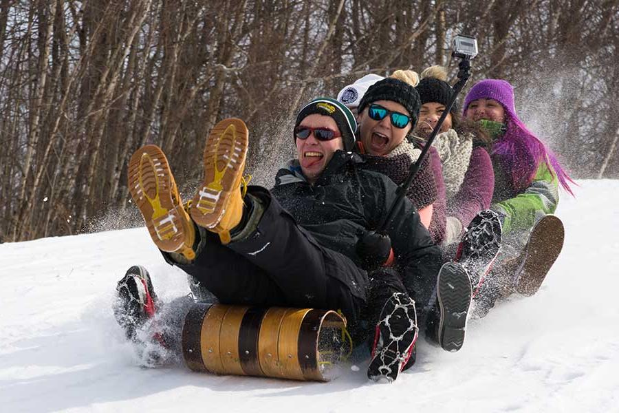 Students riding in a toboggan at winter fest